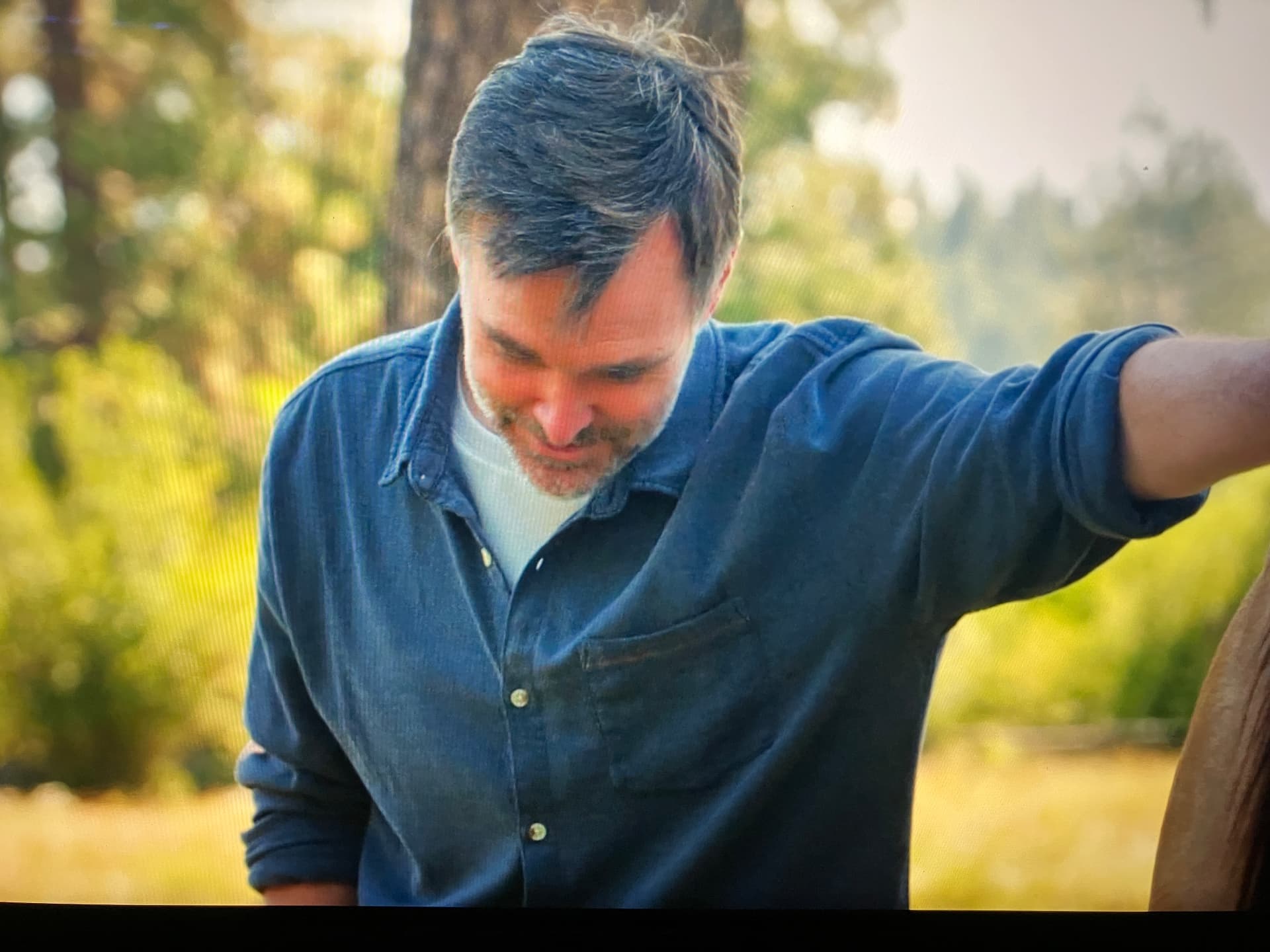 Will Forte smiling as he stands with a horse